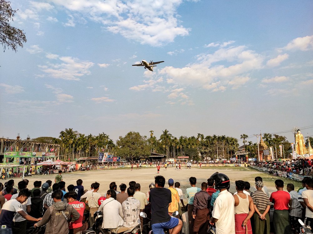 Landing Aeroplane Over a Football Match