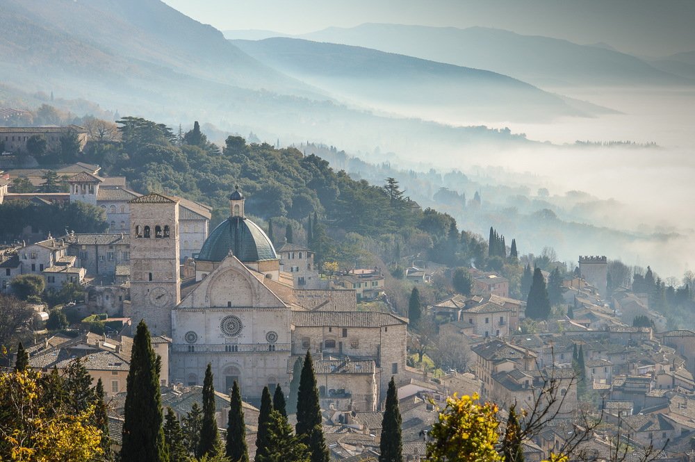 Вид на туманный город Ассизи в Италии с горы Субасио