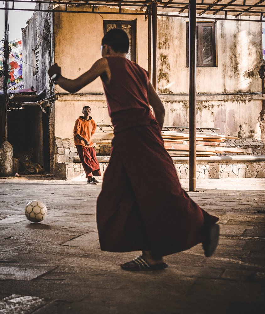 Young monk playing footbal. Nepal, Kathmandu