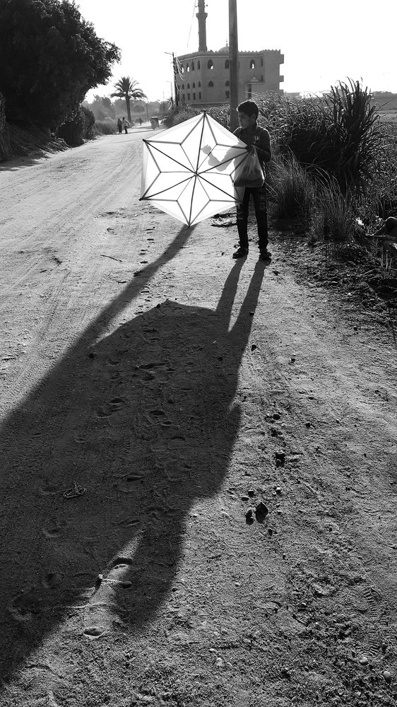 طفل يلعب ب الطائره الورقيه