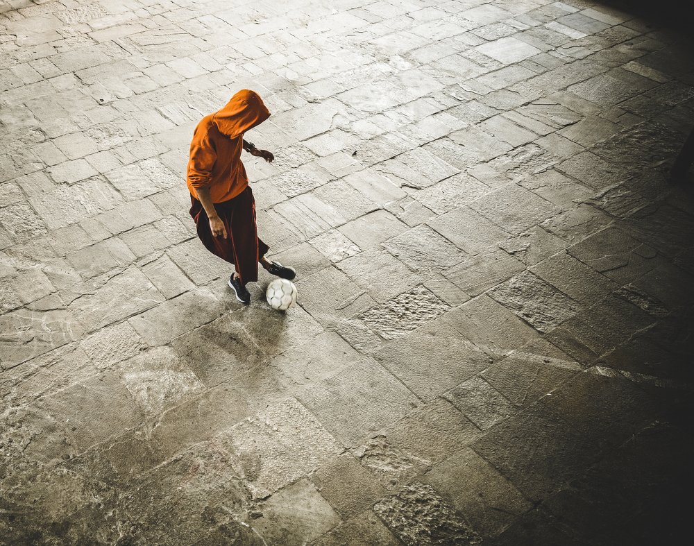 Young monk playing footbal. Nepal, Kathmandu