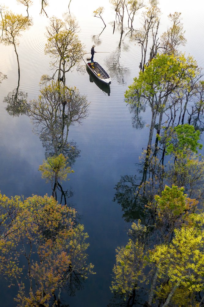 Peaceful lake surface, old man deserves fish and trees for changing seasons