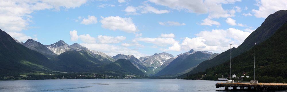 Синее небо и облака над фьордом .