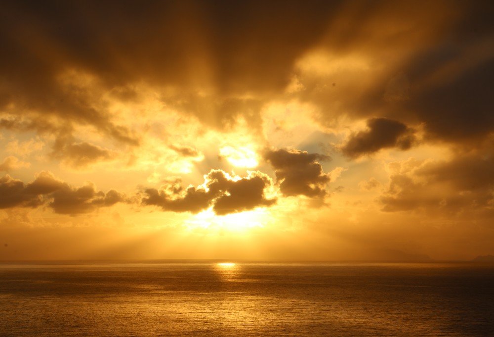 Sun rising between clouds