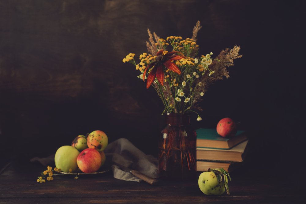 Still life with wild flowers and apples.